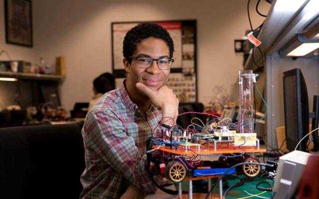 Student with a robotic vehicle he invented